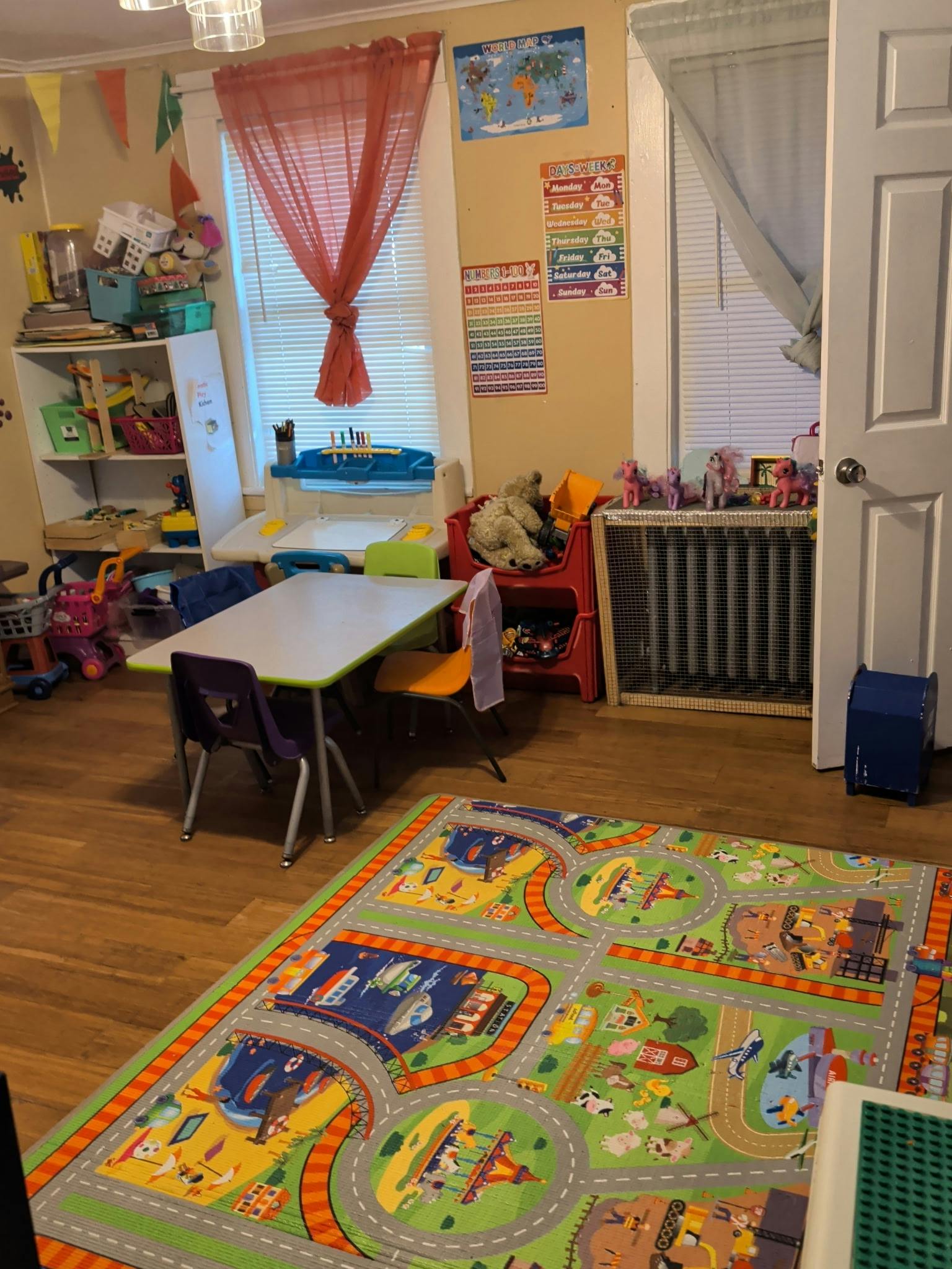 Playroom with a table and chairs on a road-themed play mat