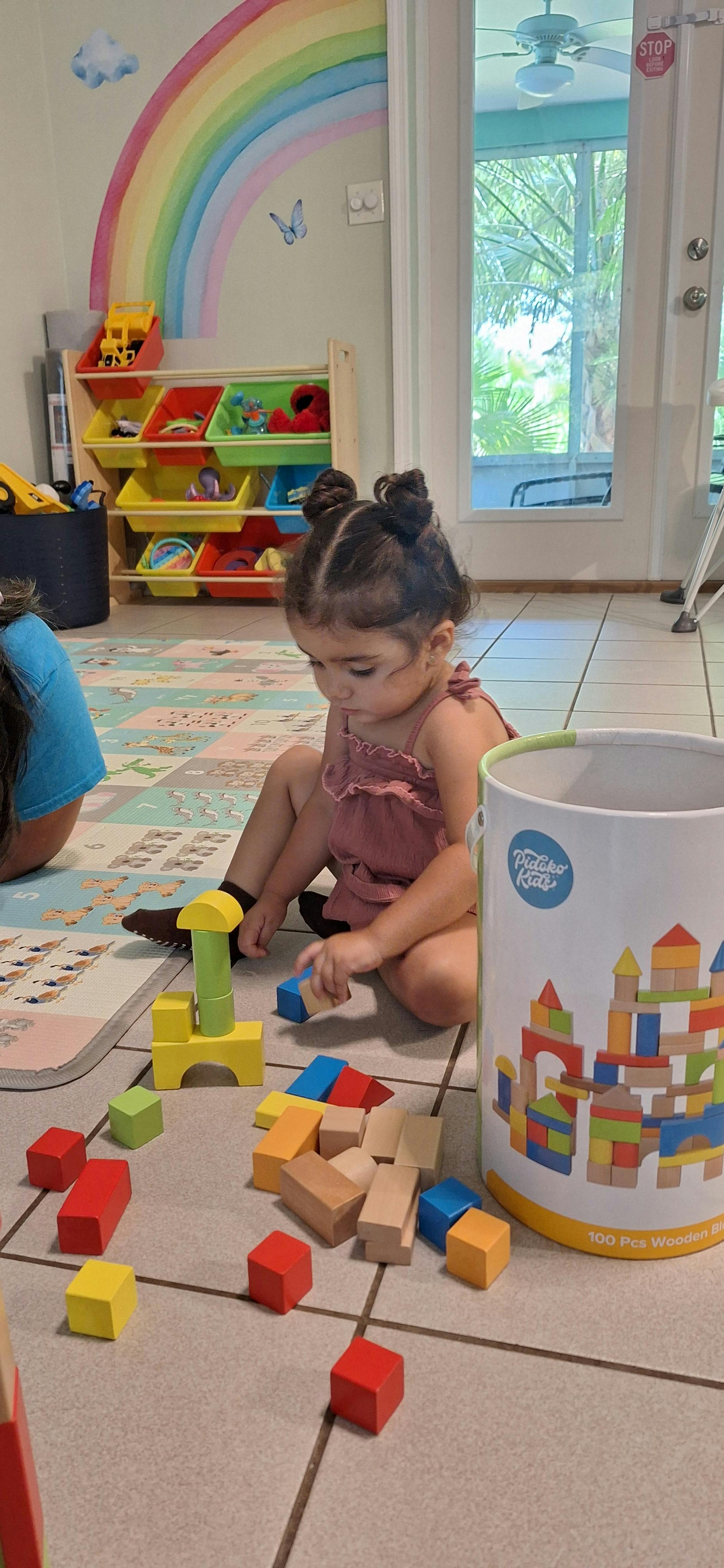 Child playing with colorful building blocks on the floor