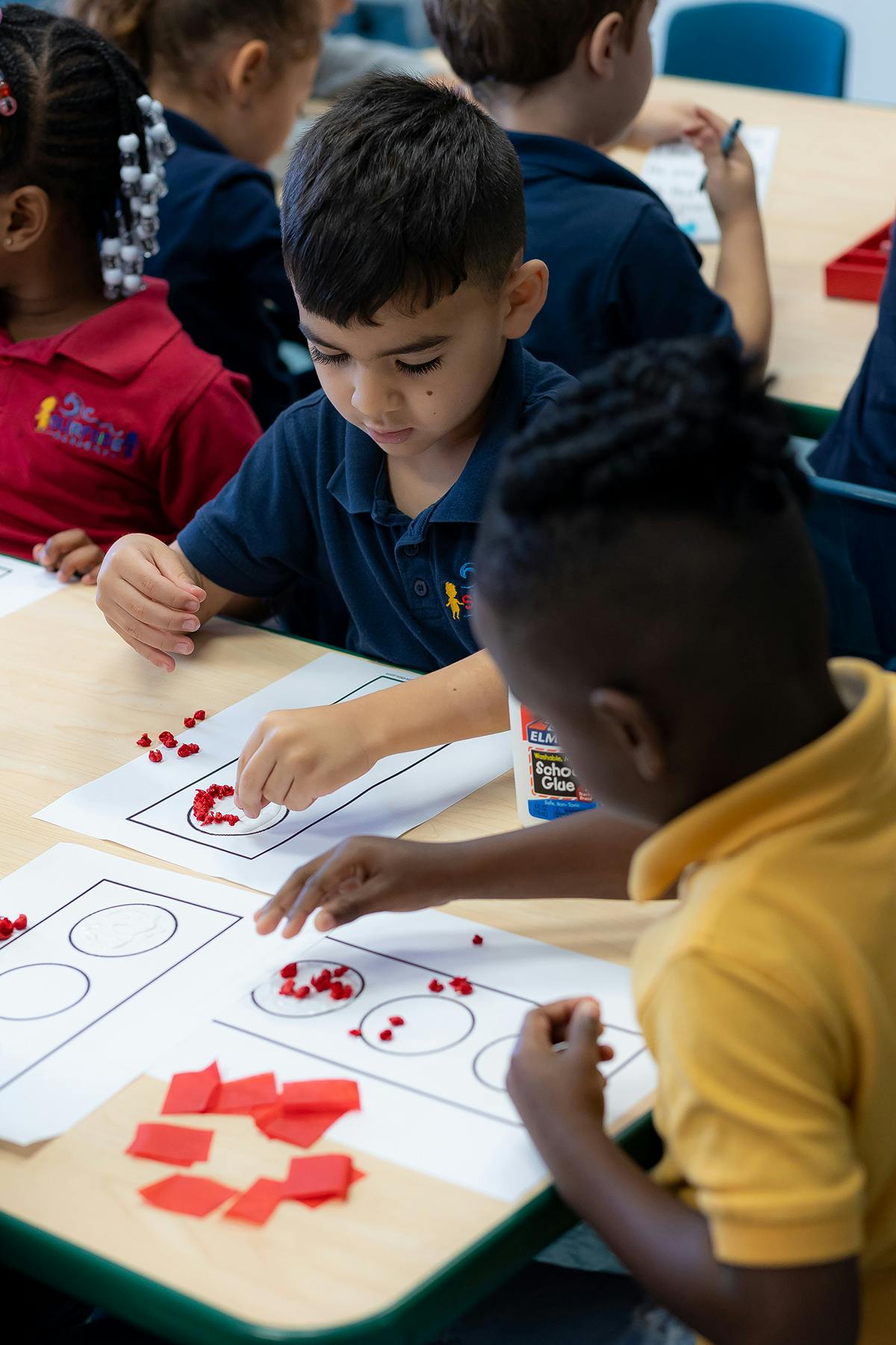 Two children working on a craft project at a table
