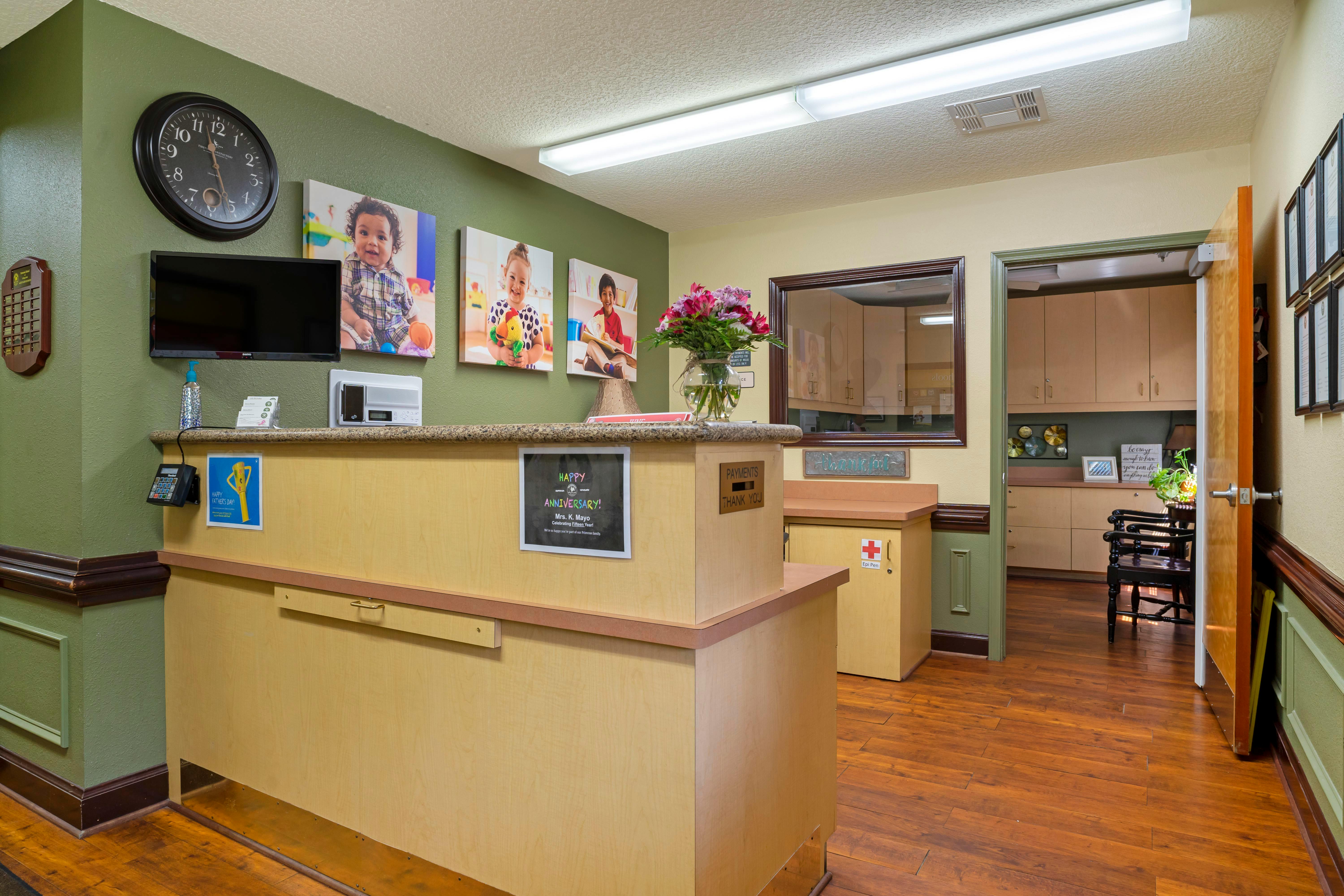 Reception desk with children's photos on the wall