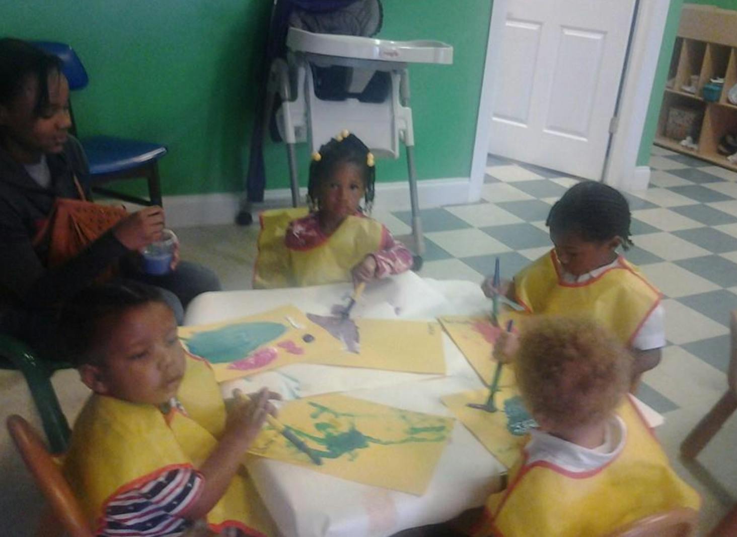 Adult and children painting at a table
