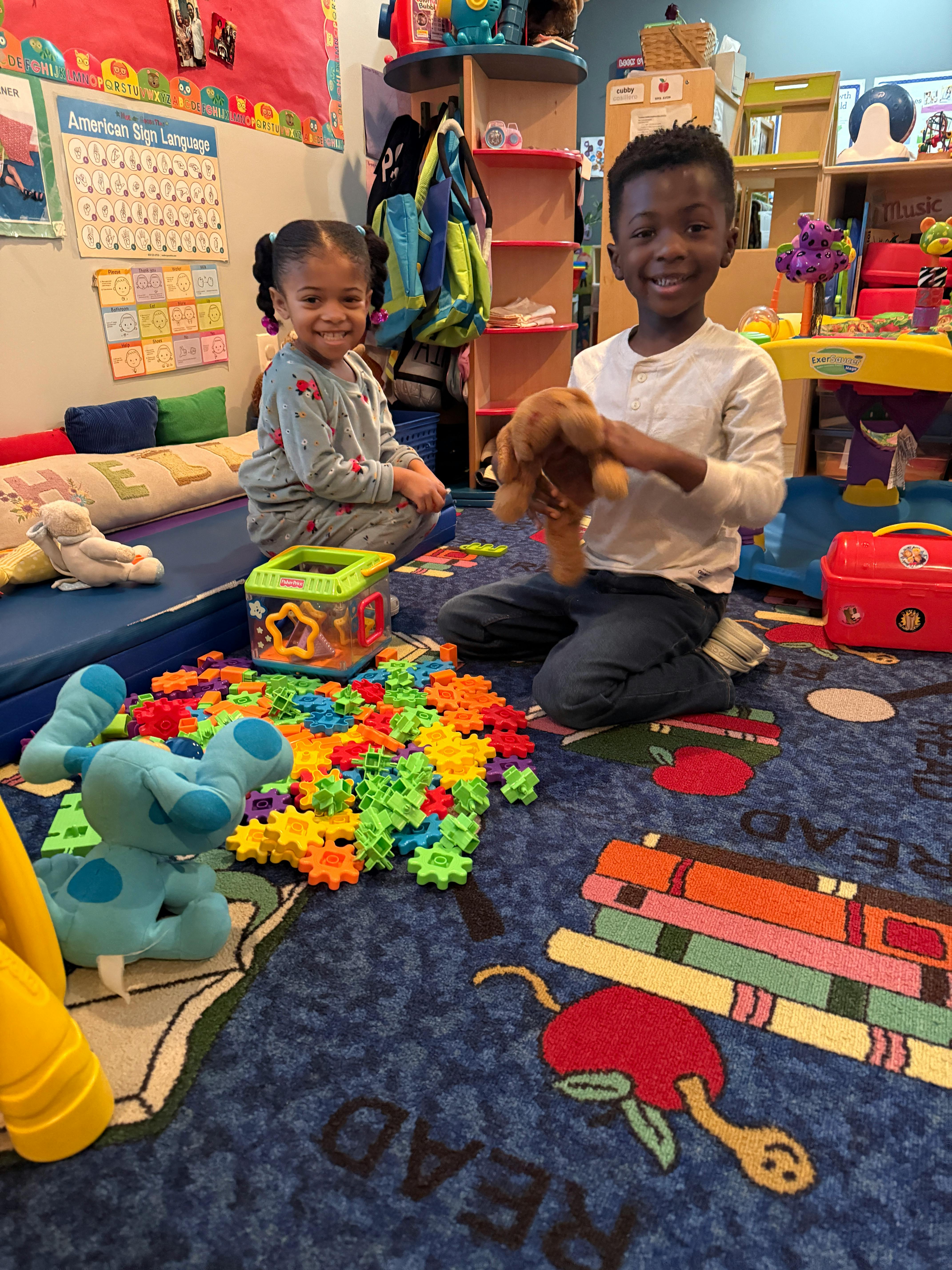Two children playing with toys on a rug