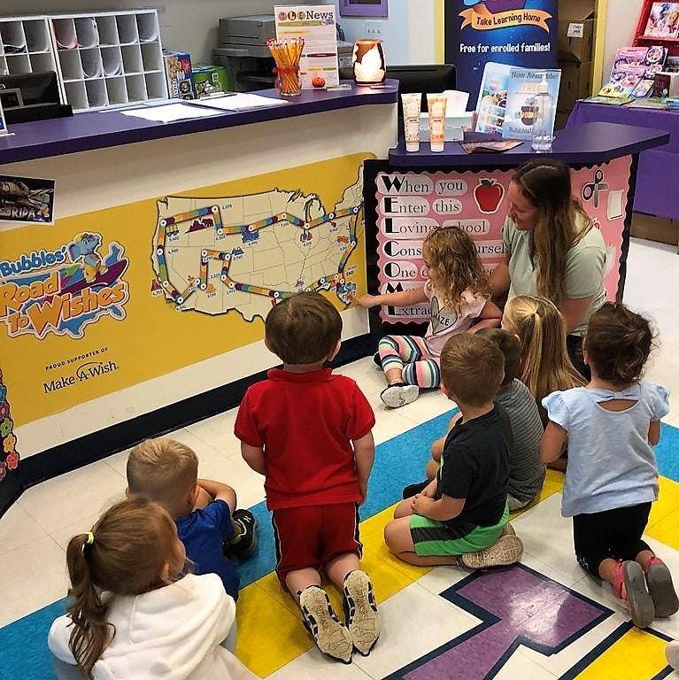 Adult and children looking at a map on a wall
