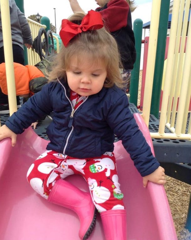 Child on a pink slide at a playground