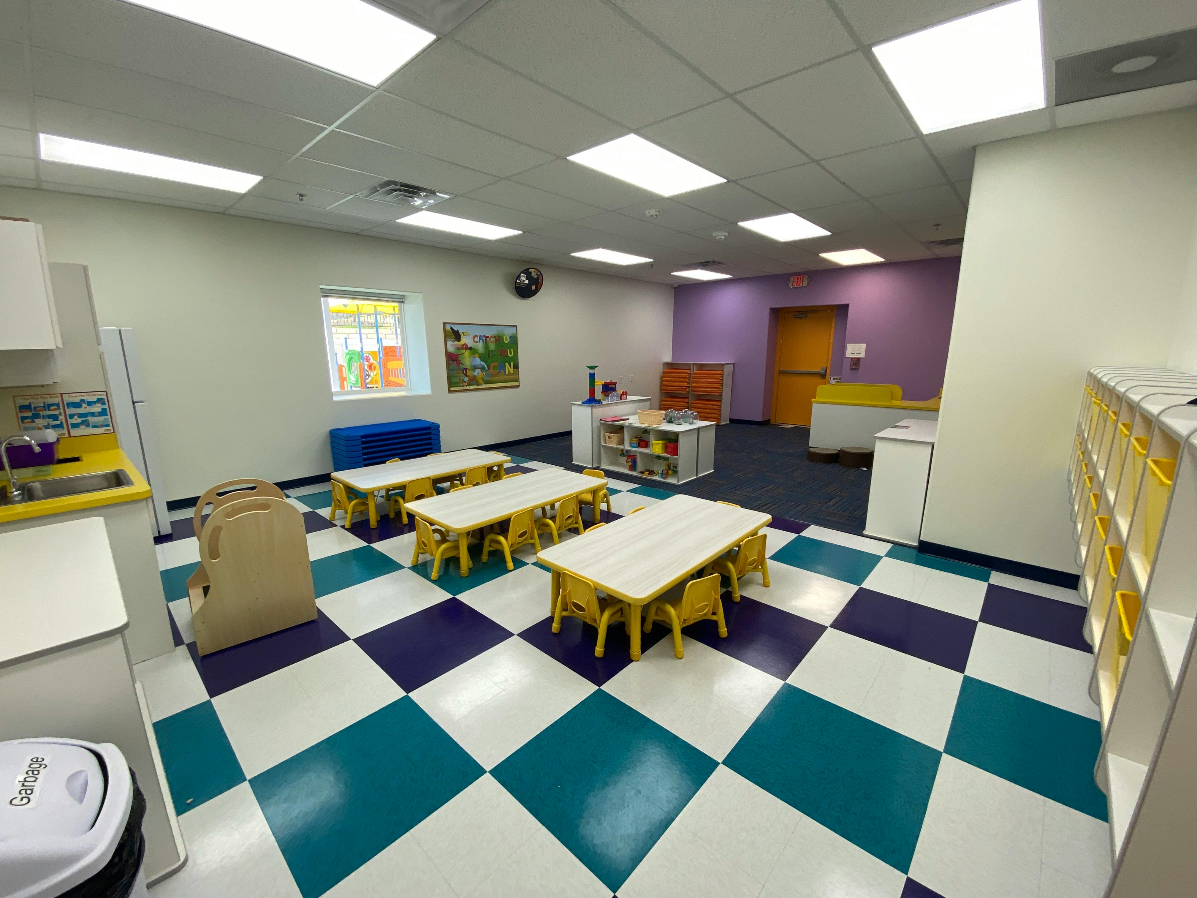Classroom with small tables and chairs on a checkered floor