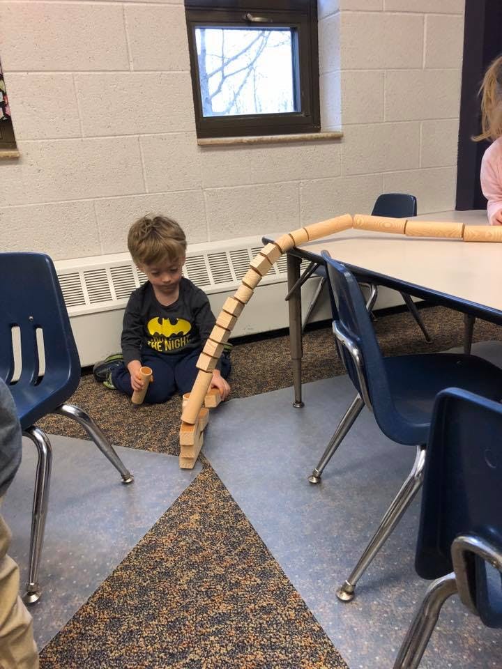 Child sitting on floor playing with wooden blocks