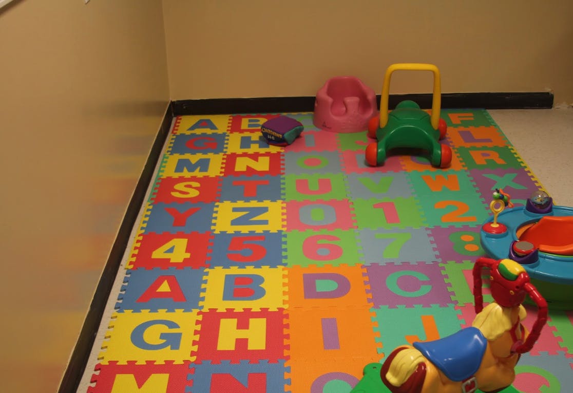 Playroom with alphabet and number floor mats and various toys
