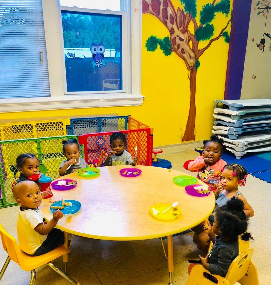 Children sitting around a table with plates and utensils