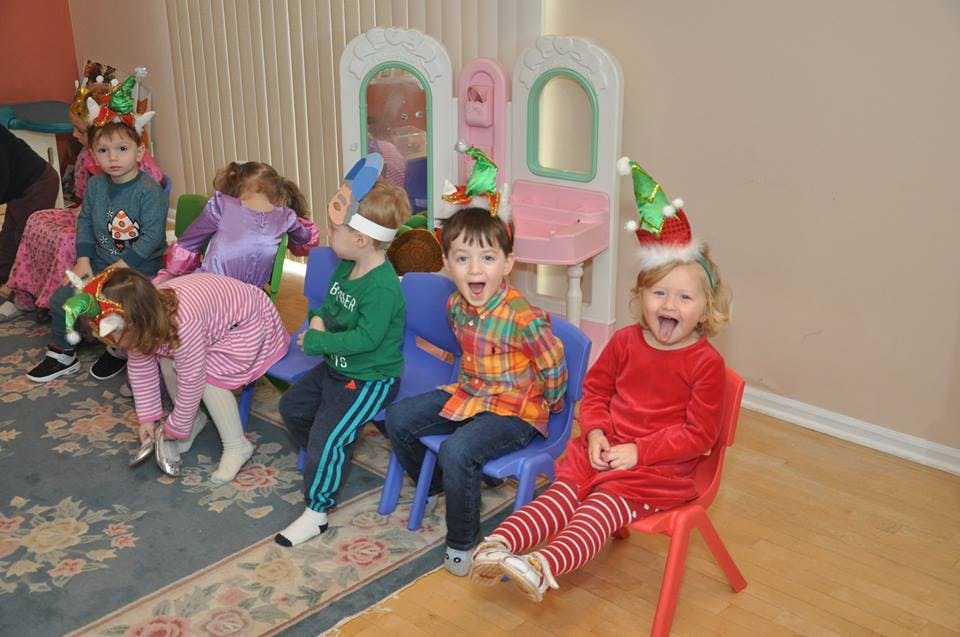 Children in holiday hats sitting and standing indoors