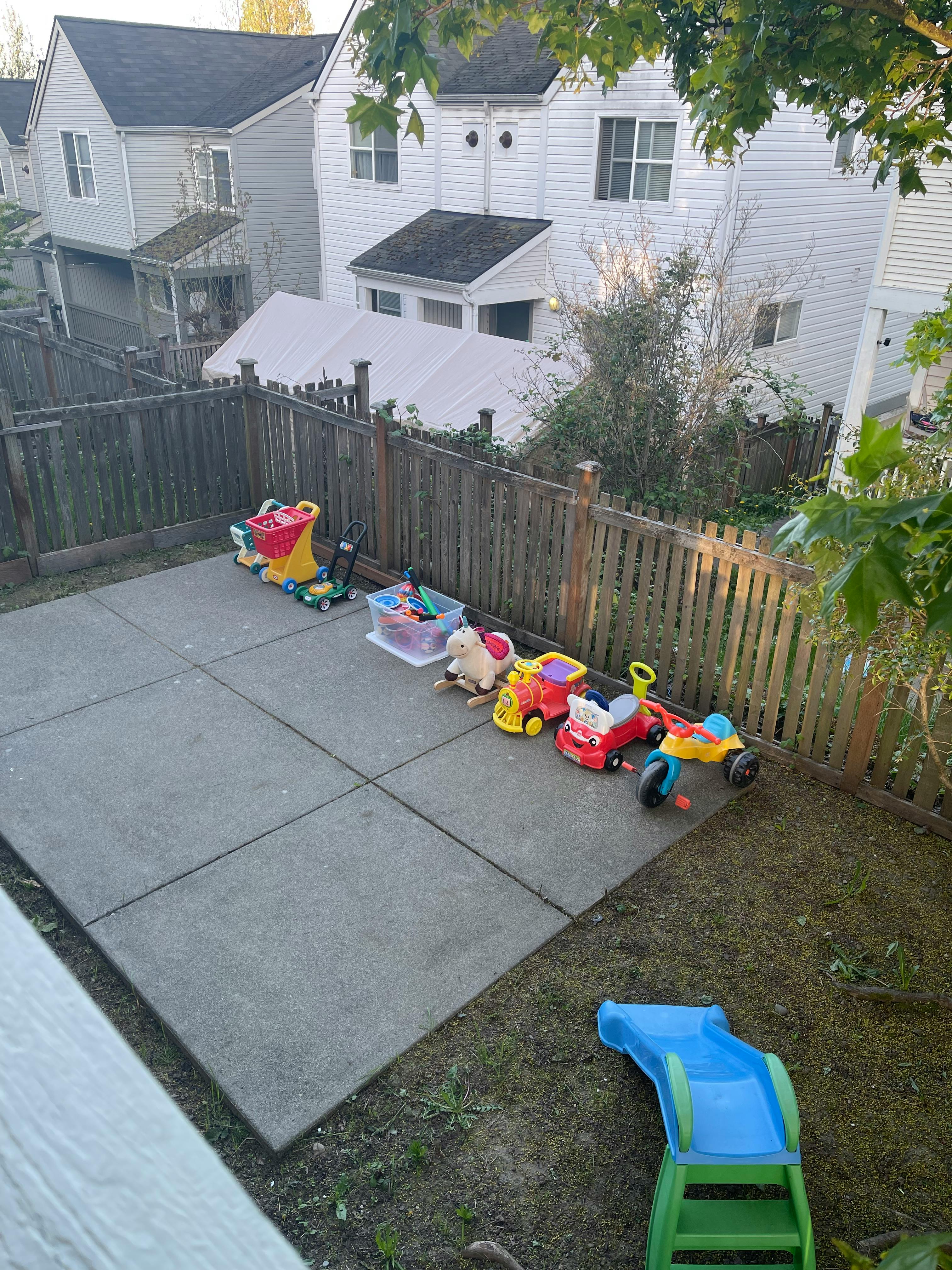 Backyard patio with children's toys and a slide