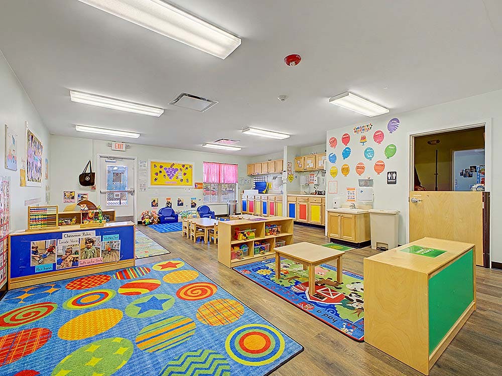 Colorful and organized classroom with tables, chairs, and learning materials