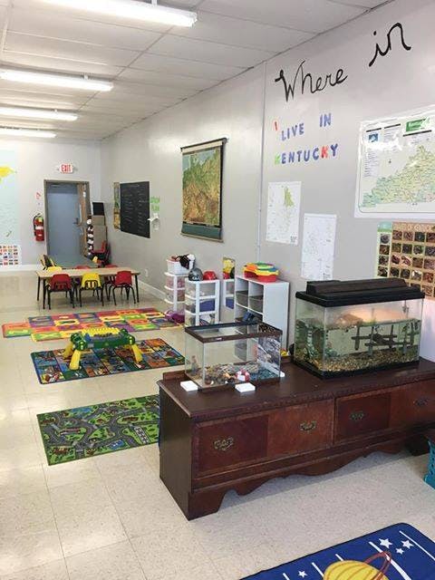 Classroom with tables, chairs, rugs, and aquariums