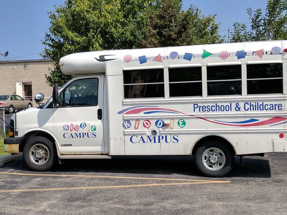 White bus with "Preschool & Childcare" and "Campus" written on the side
