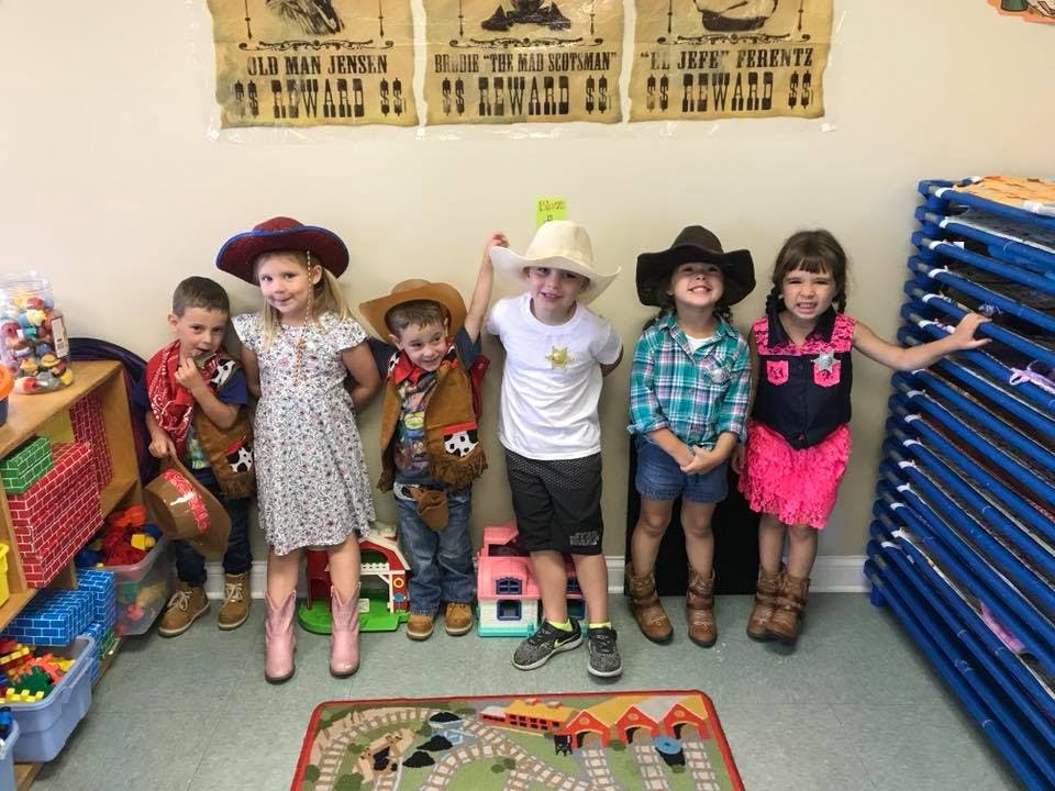 Group of children dressed in cowboy hats and vests