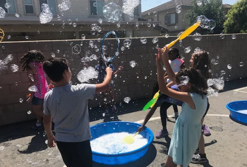 Children playing with bubbles outdoors