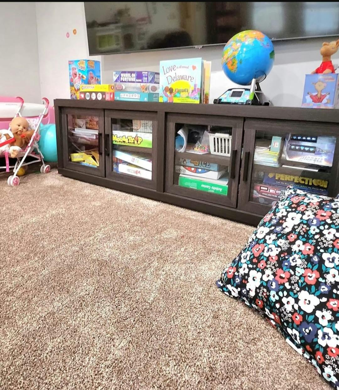 Board games and a globe displayed on a media console in a room