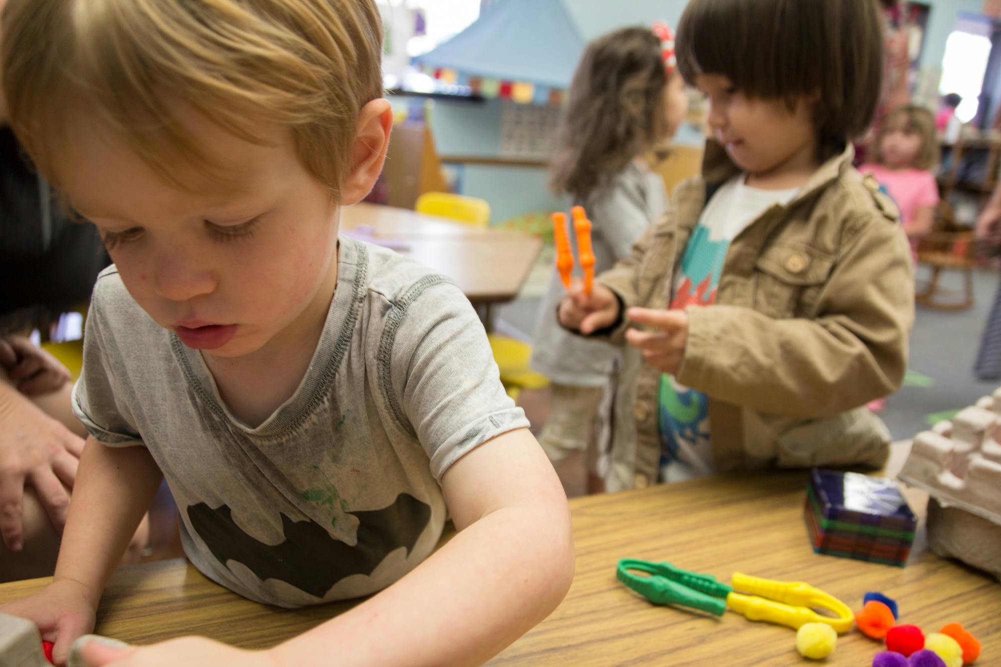Two children playing with toys at a table
