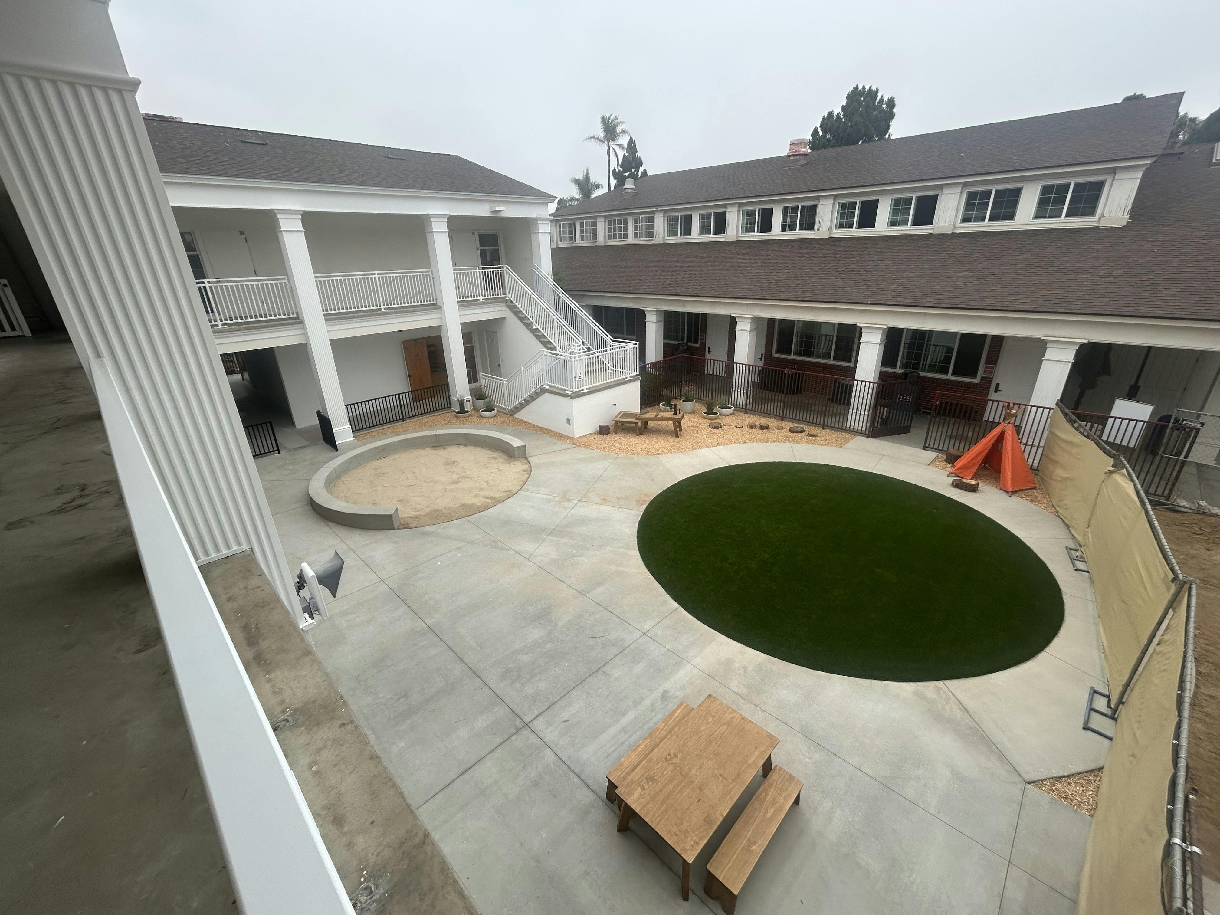 Courtyard with sand pit, artificial grass circle, and wooden table