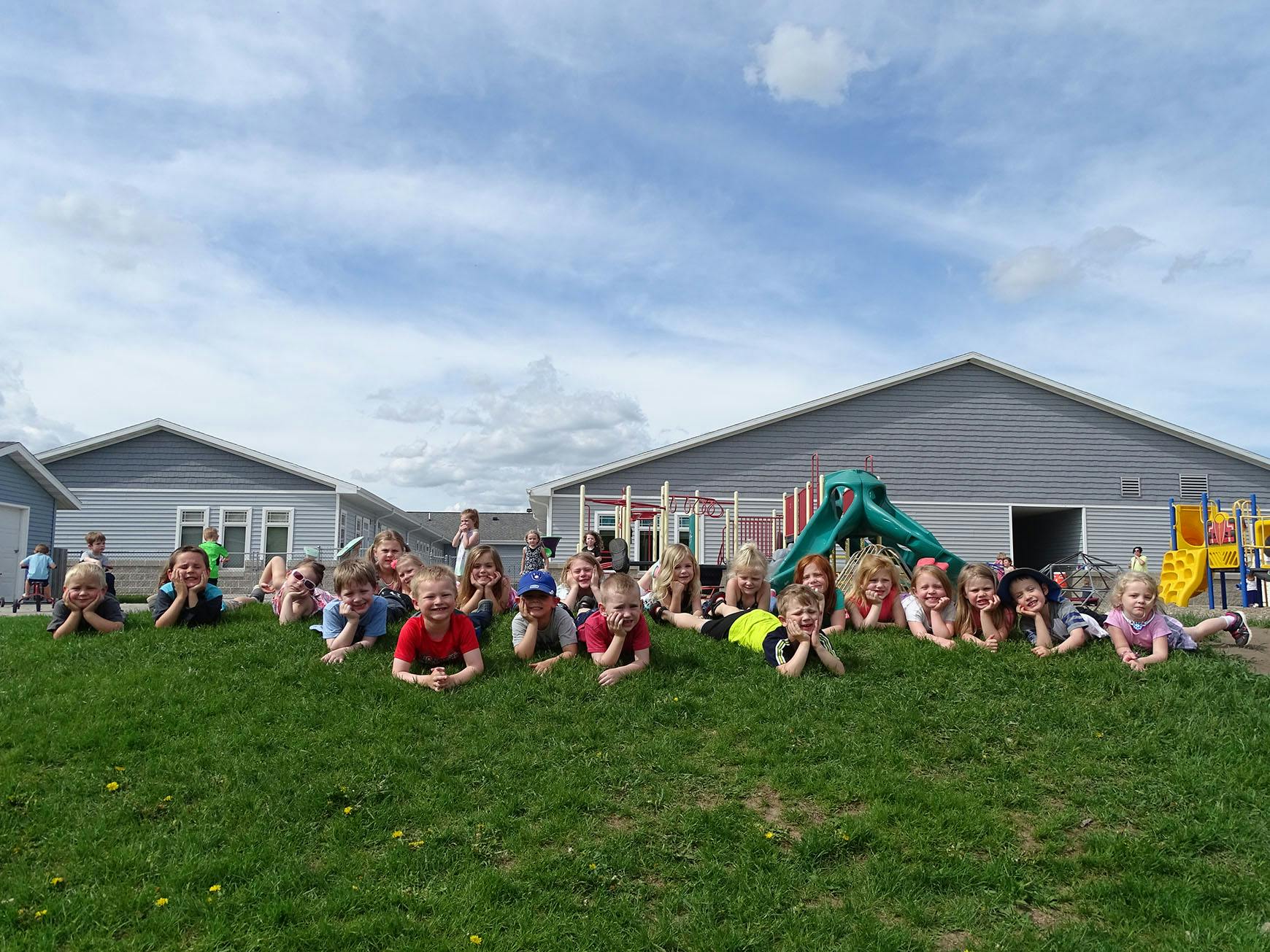 Group of children lying on a grassy hill