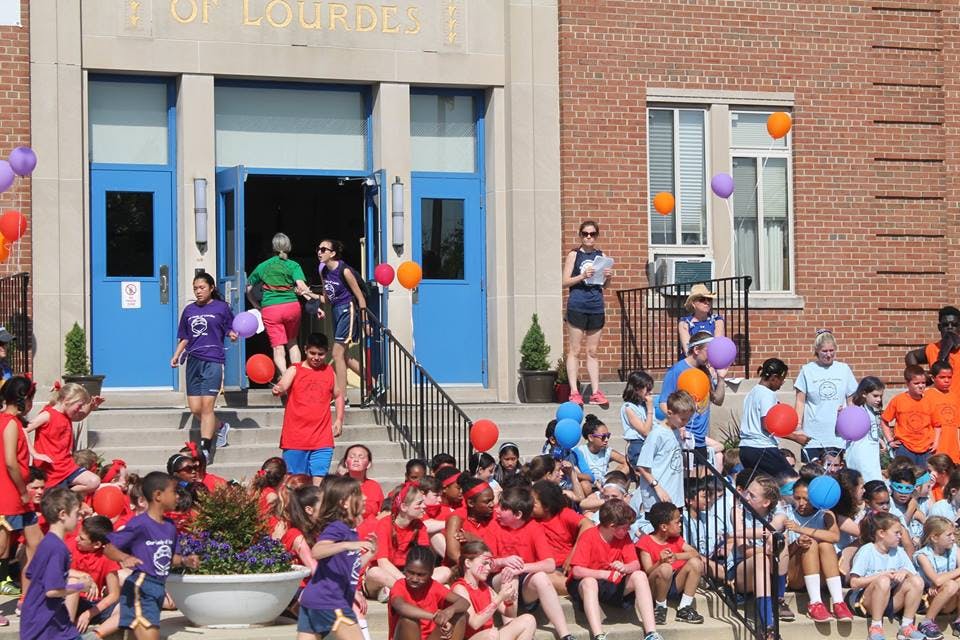 People and children gathered on steps outside a building
