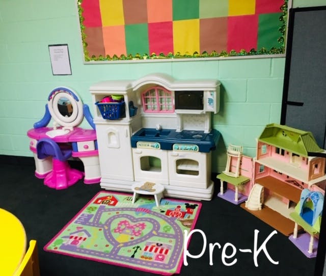 Play kitchen, vanity, and dollhouse in a classroom