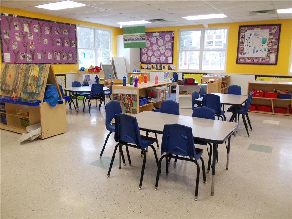 Empty colorful classroom with small tables and chairs