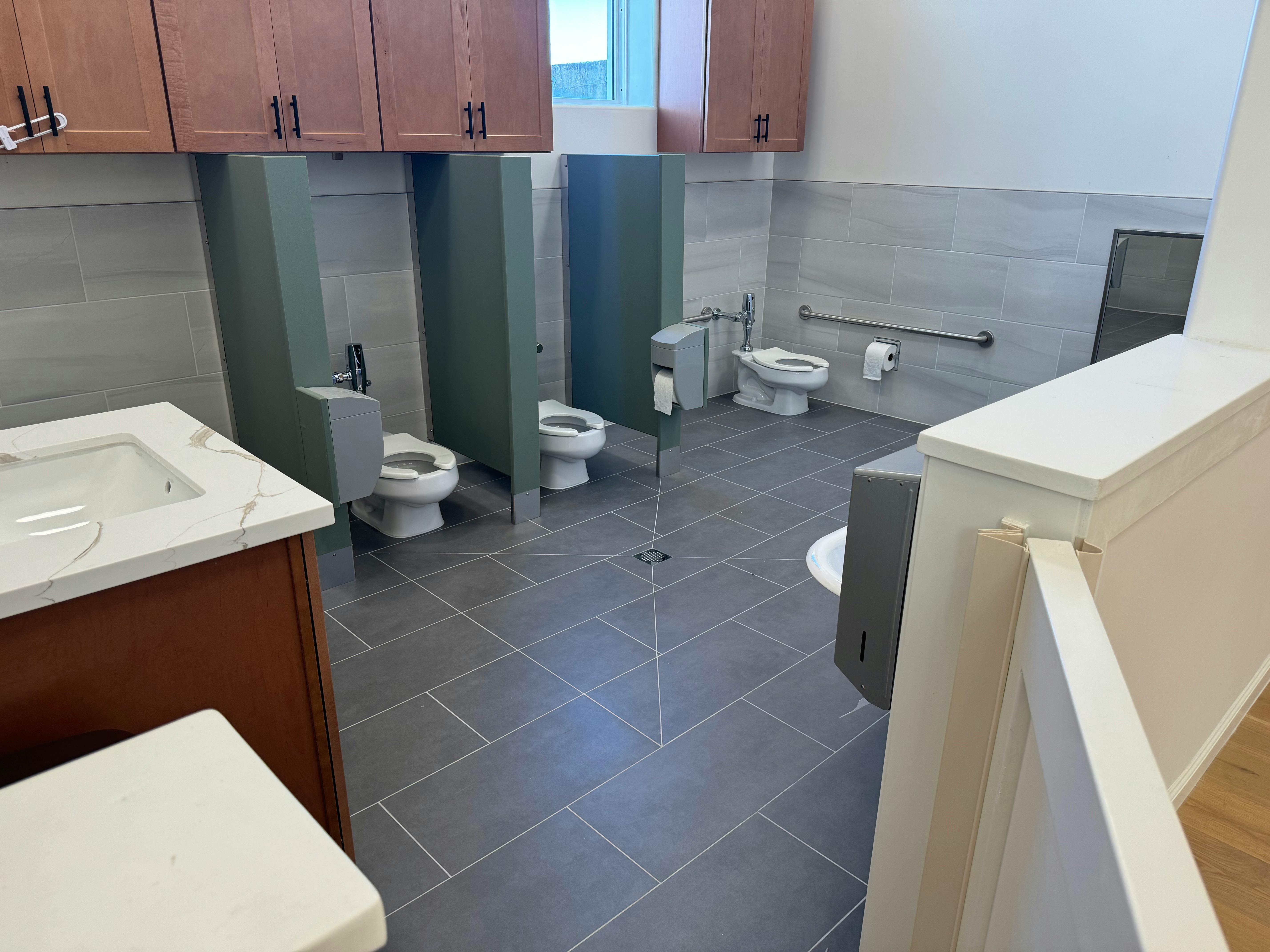 Public restroom with multiple stalls and sinks