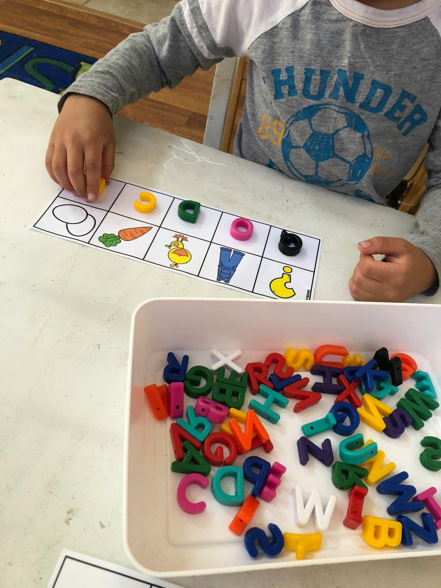 Child playing with letter rings and a matching game