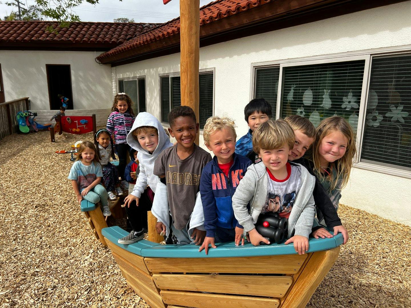 Group of children in a wooden play boat