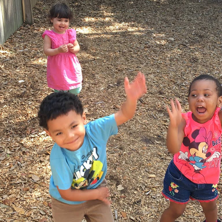 Three children playing outdoors