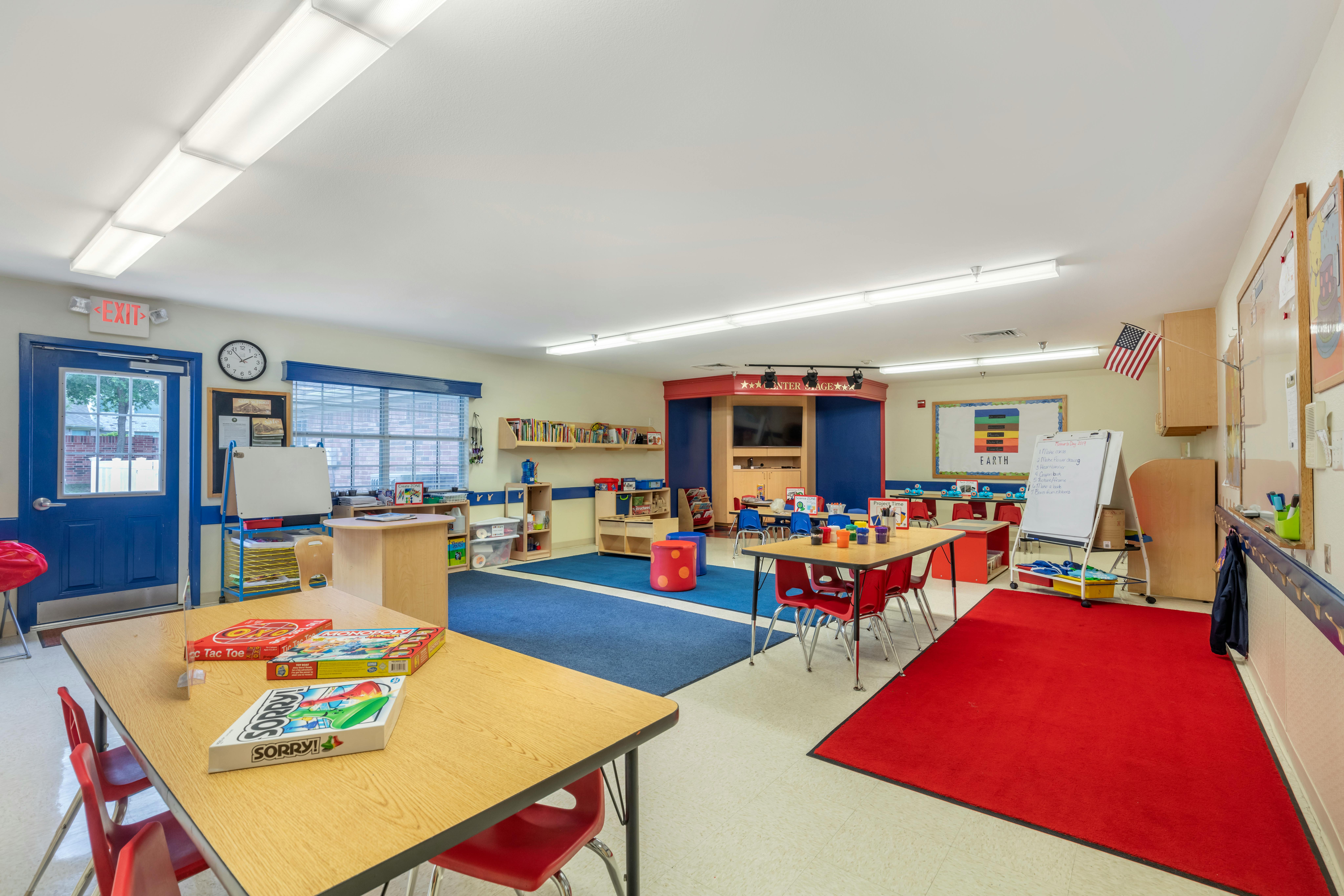 A colorful classroom with tables, chairs, and learning materials