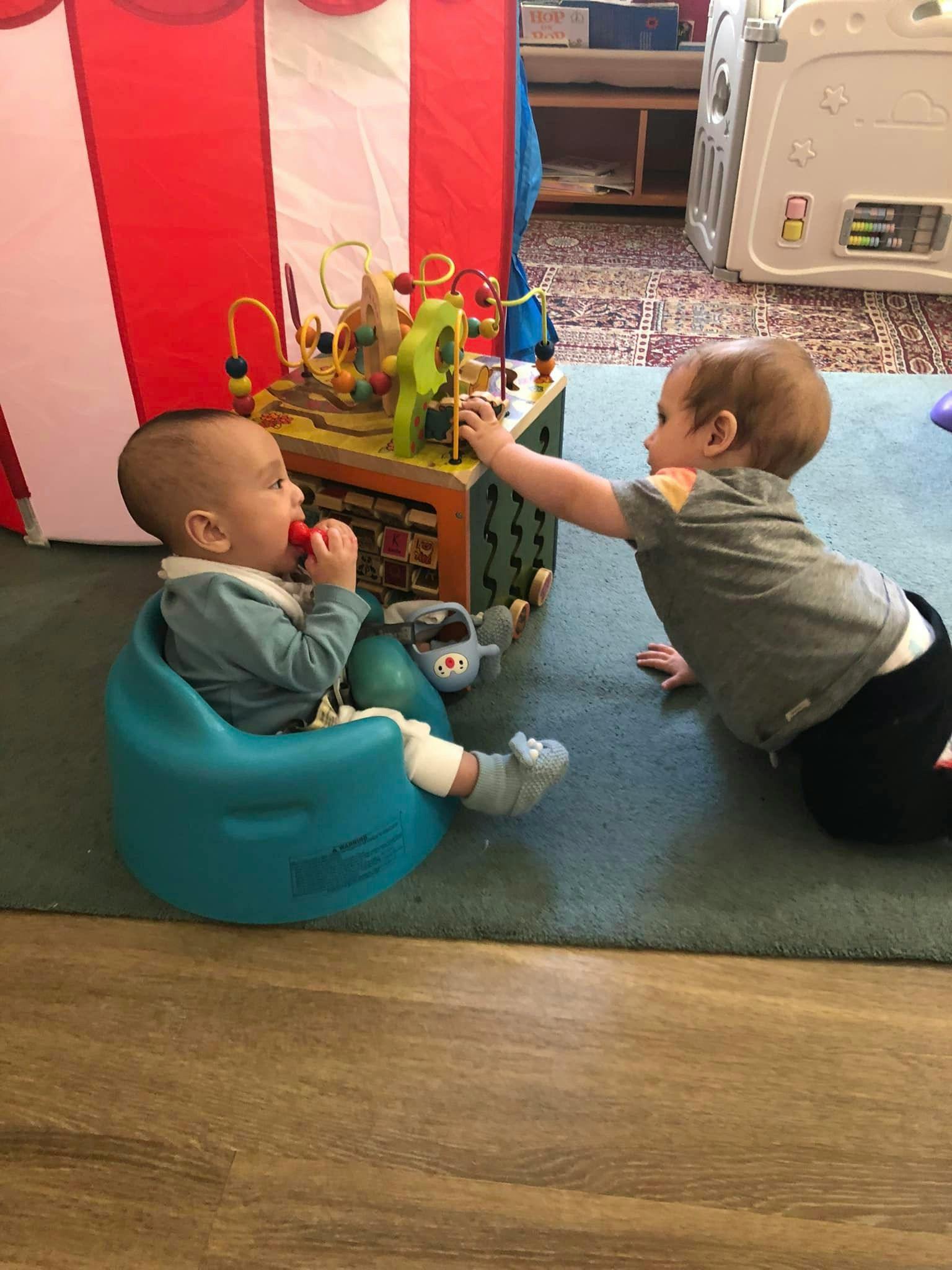 Two children playing with an activity cube