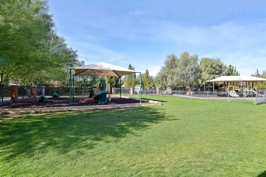 Playground with shade structures and green grass