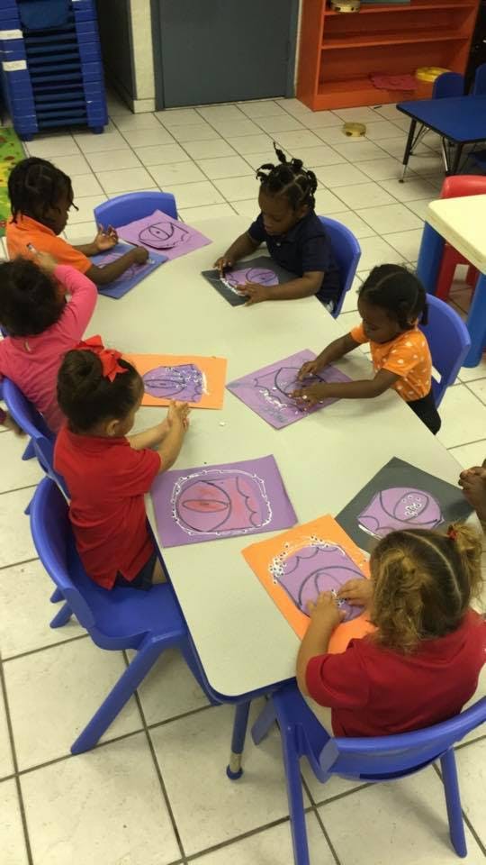 Children sitting at a table doing crafts