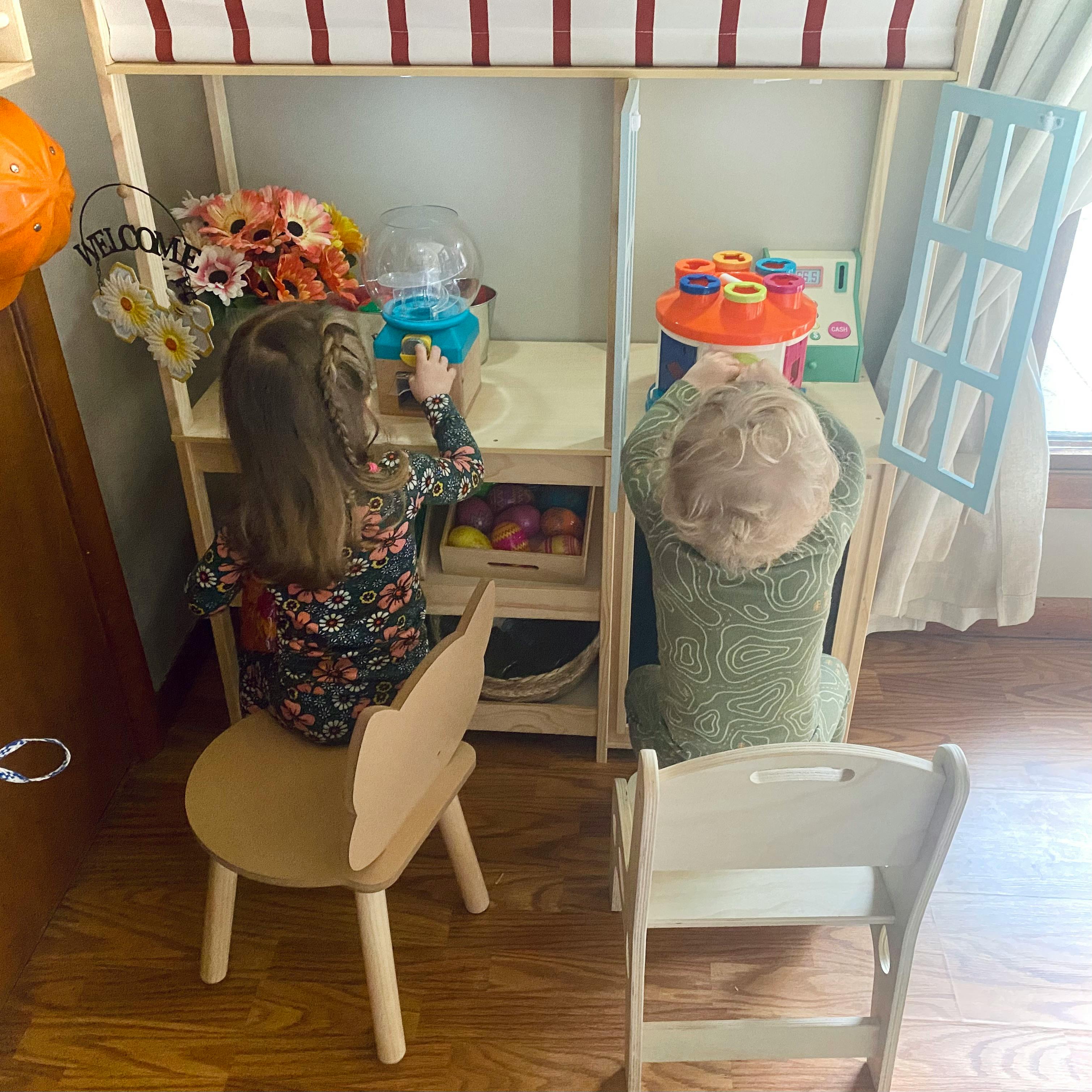 Two children playing with a toy stand