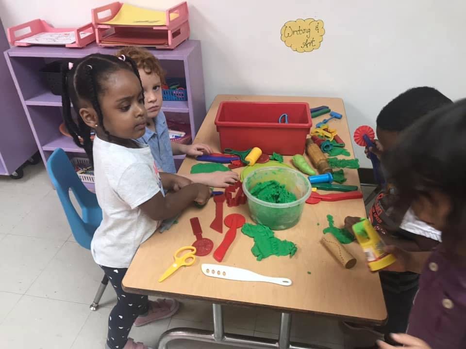 Children playing with modeling clay at a table