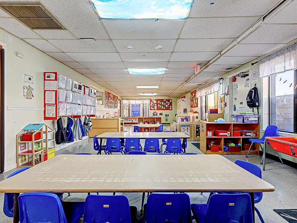Classroom with tables and blue chairs arranged in rows