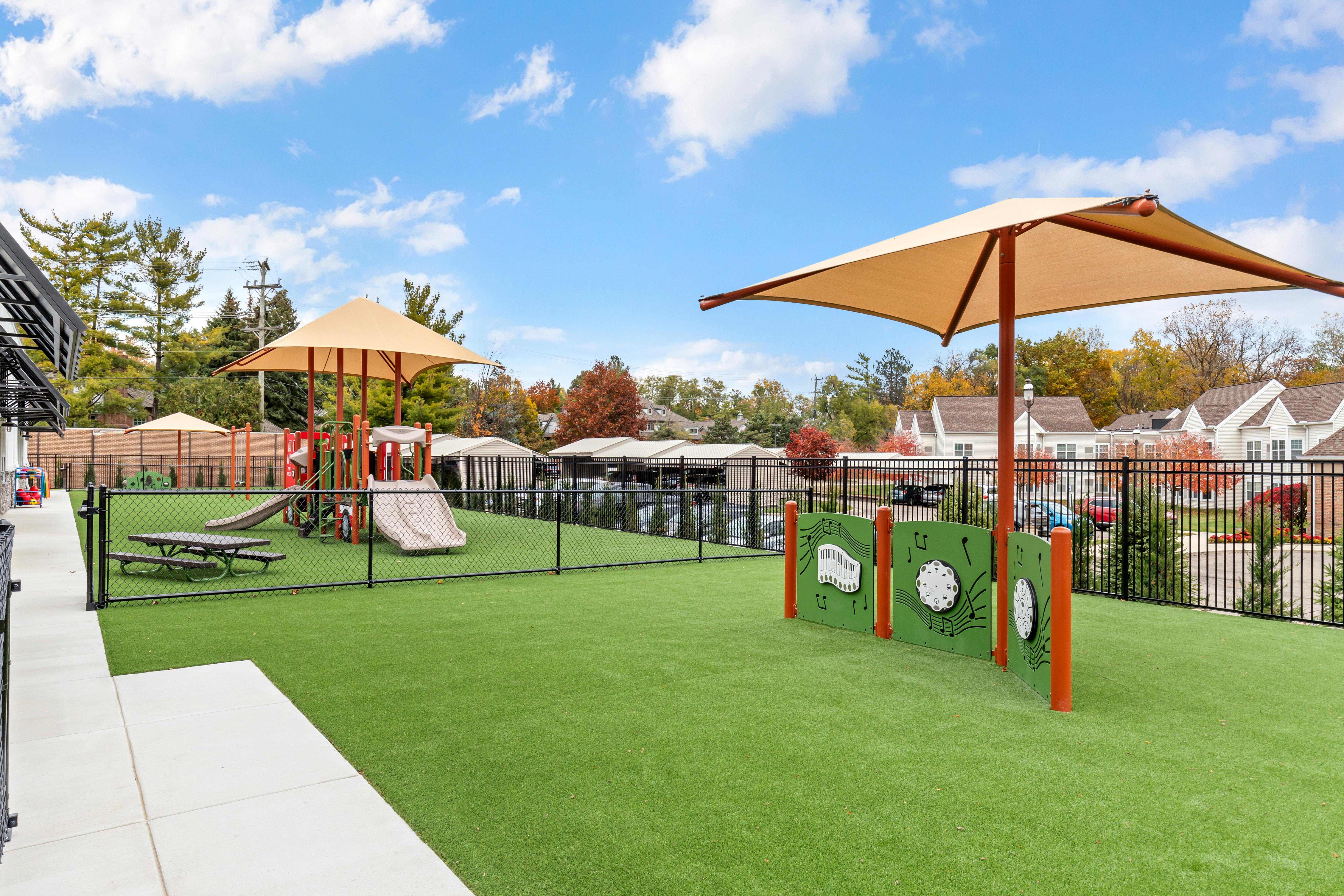 Playground with swings, slides, a small picnic table, and musical panels