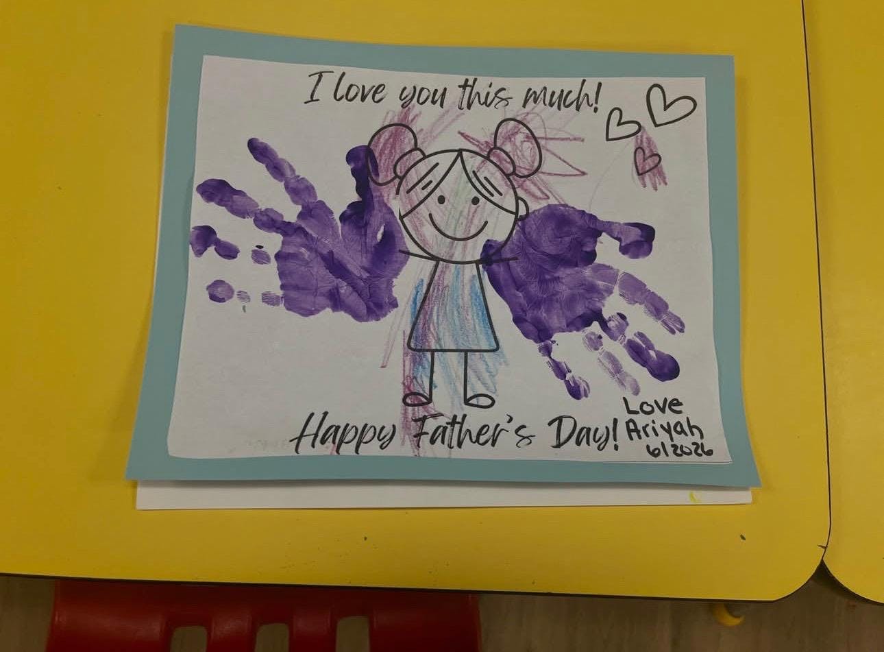 Child drawing with purple handprint wings and Father Day message