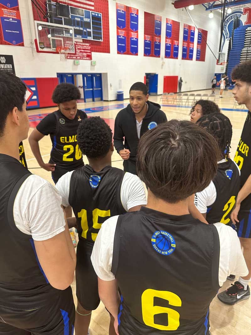 Basketball coach talking to team in a huddle on a court