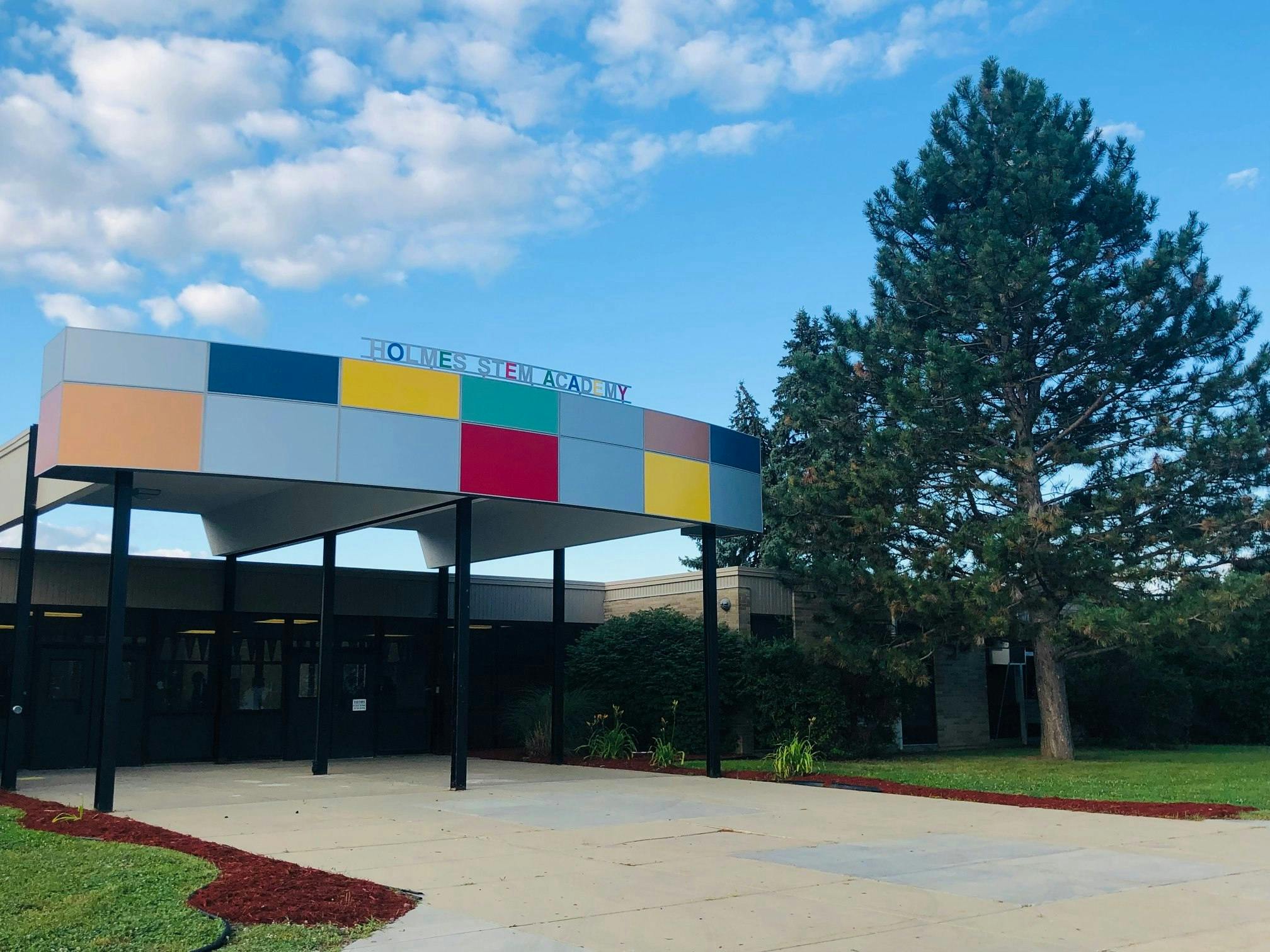 Building entrance with a colorful facade and a large tree