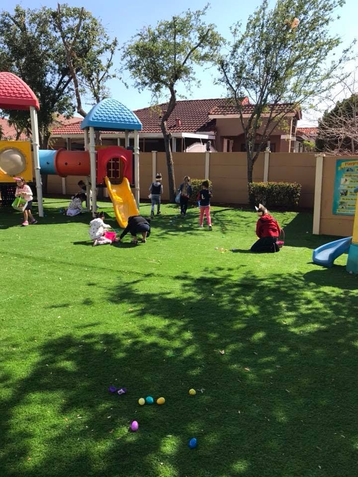 Children playing on a playground with a slide and climbing structure