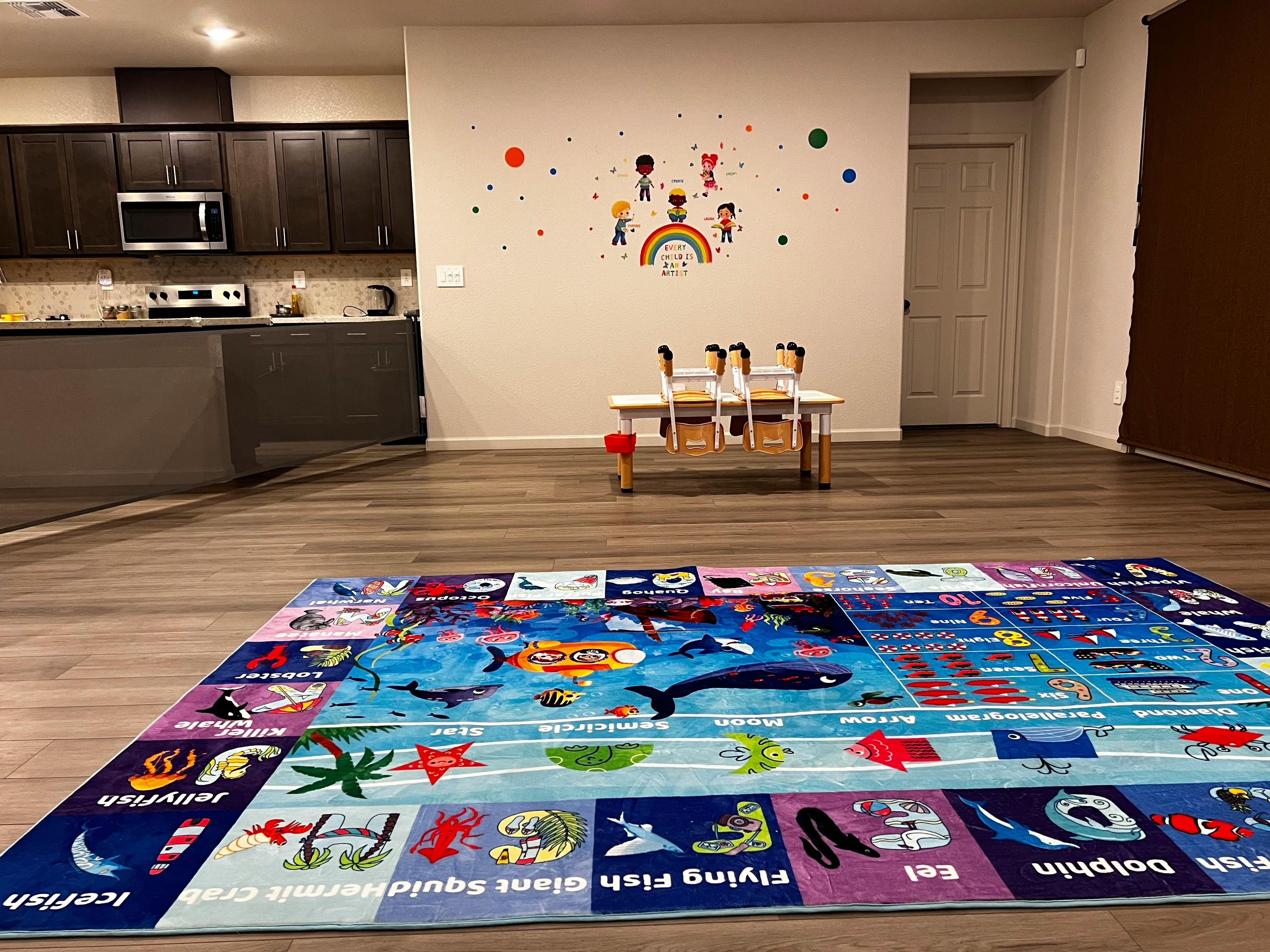 Playmat on a wooden floor in a room with a kitchen in the background