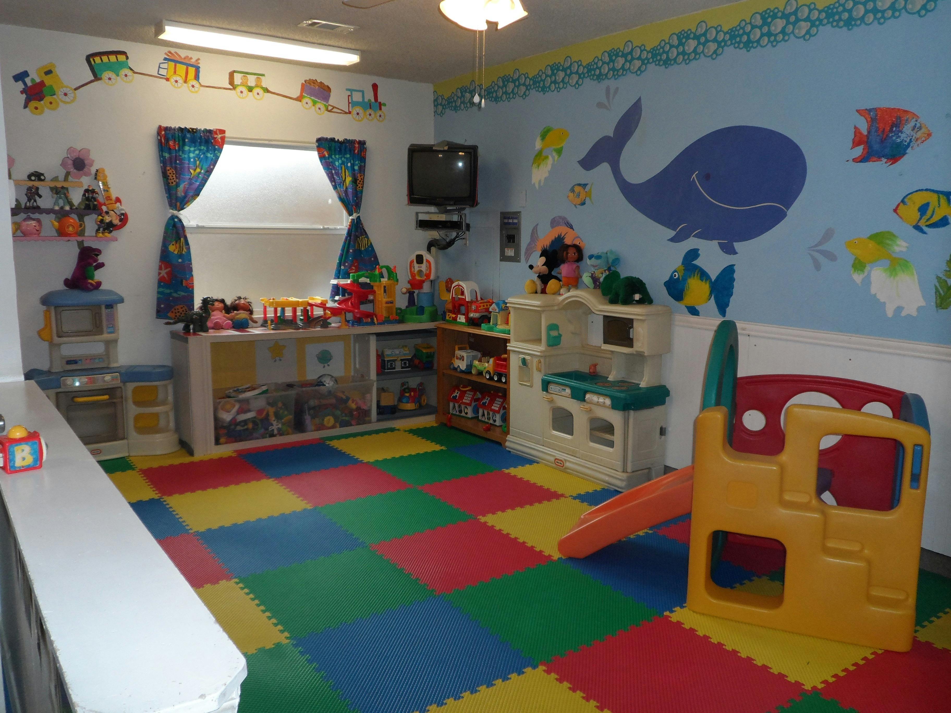 Playroom with colorful floor tiles, toys, and a small slide