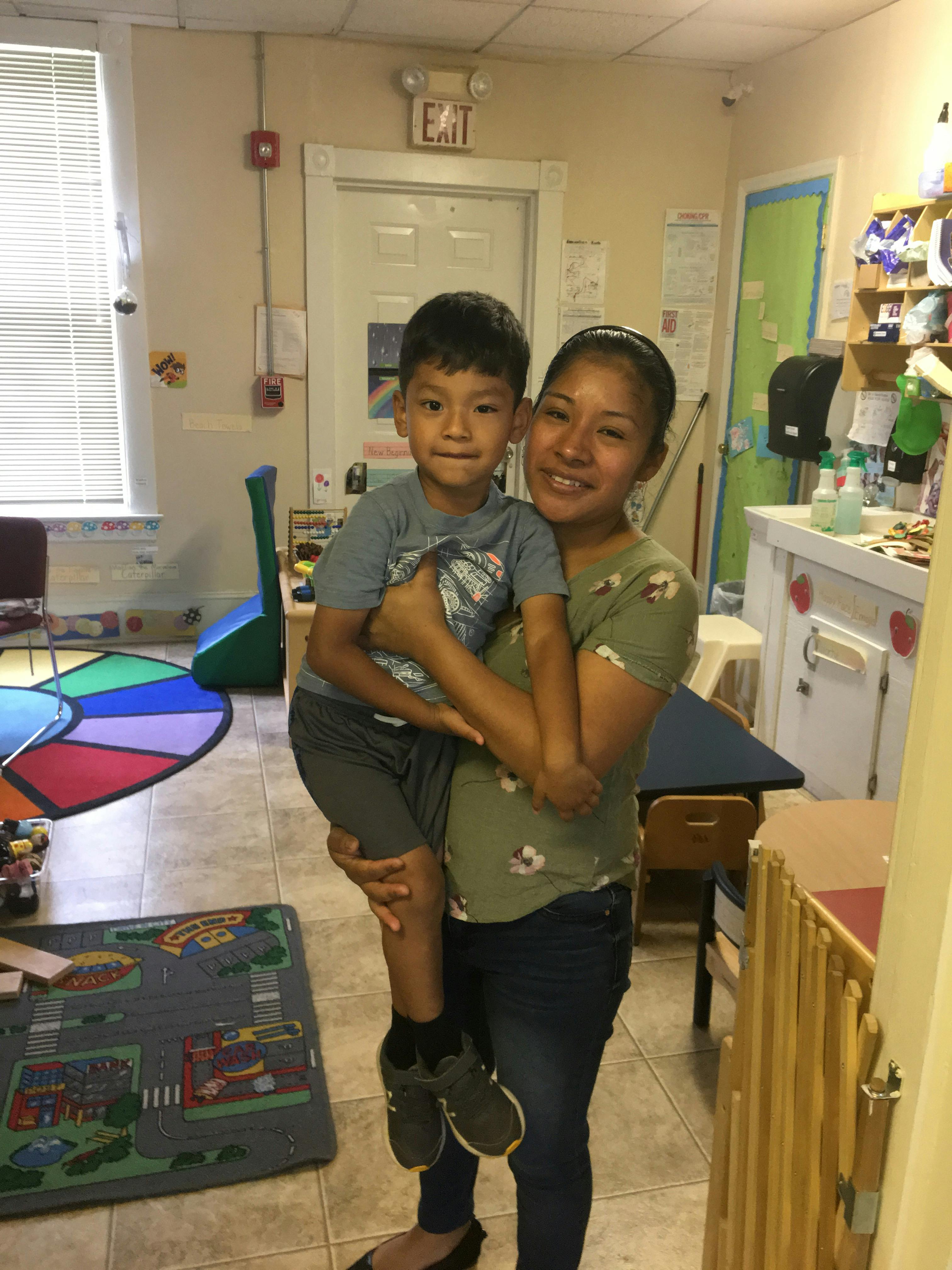 Person holding a child in a classroom