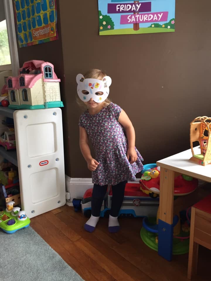 Child wearing a white animal mask