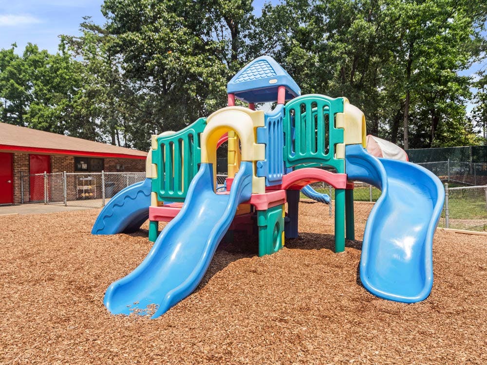 Playground with multiple slides on wood chip ground