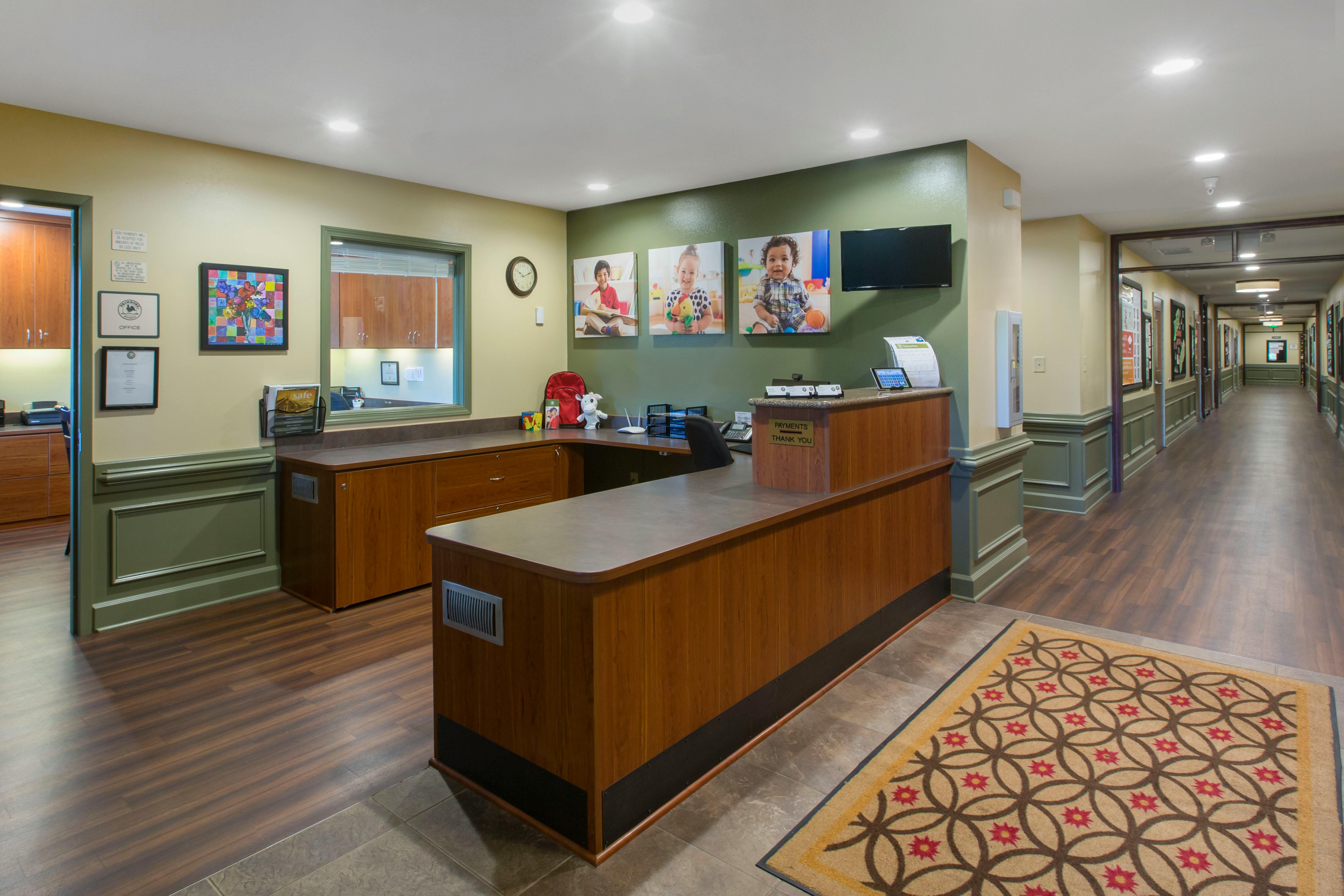 Reception area with a wooden desk and a long hallway