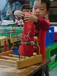 Child playing with a bead maze toy
