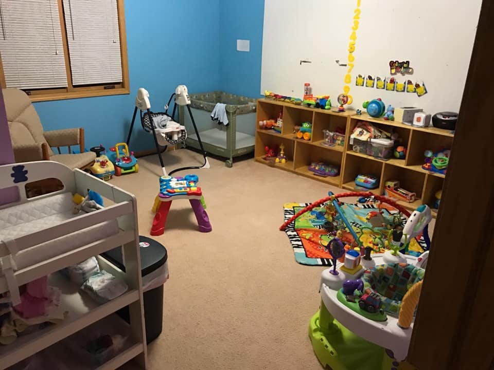 Nursery room with crib, changing table, and various baby toys